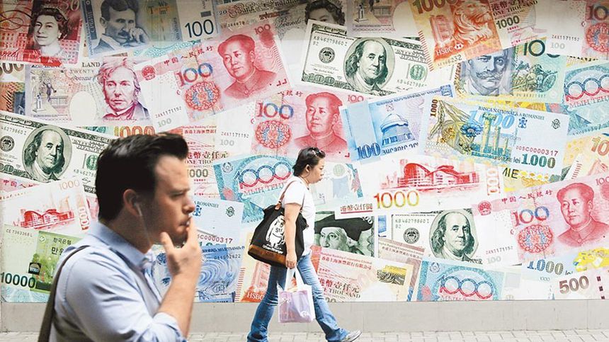 图为行人经过香港一处有人民币，美元等货币图示的换汇中心（AP/美联社）