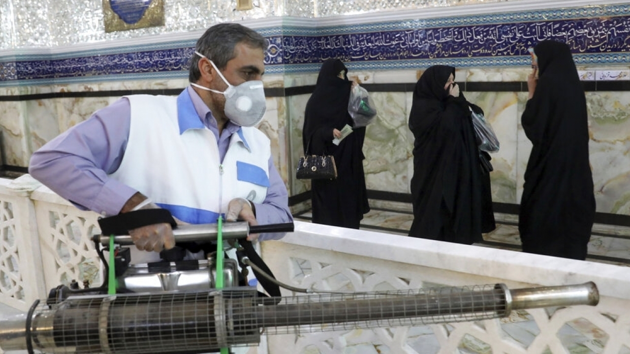 伊朗工作人員於寺廟進行消毒。（美聯社）