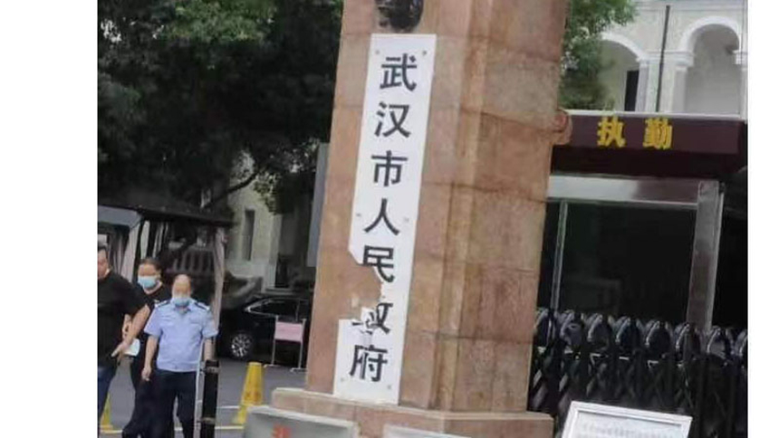 7月17日，網傳武漢女子用斧頭砍爛市政府門牌。（網絡圖片）