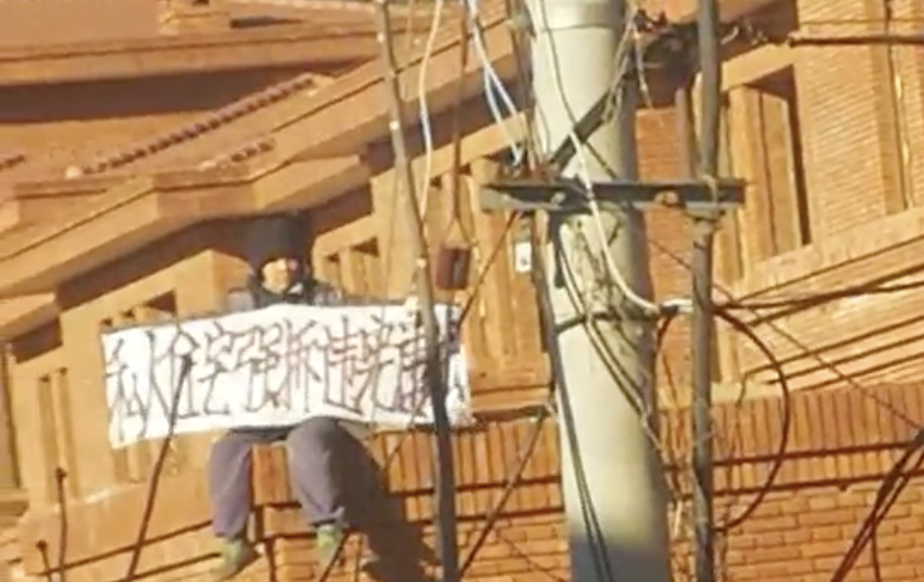 香堂村一名女業主持橫幅抗議強拆。