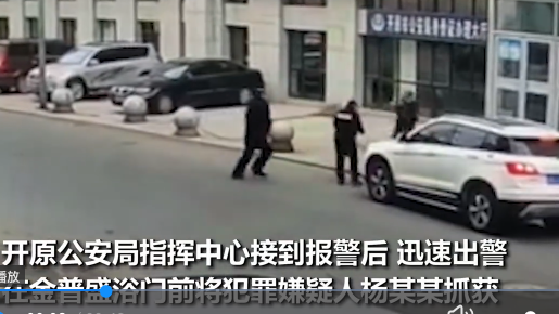 辽宁开原市一男子当街持刀无差别砍人。图为该男子与赶来的警察打在一起。（视频截图）