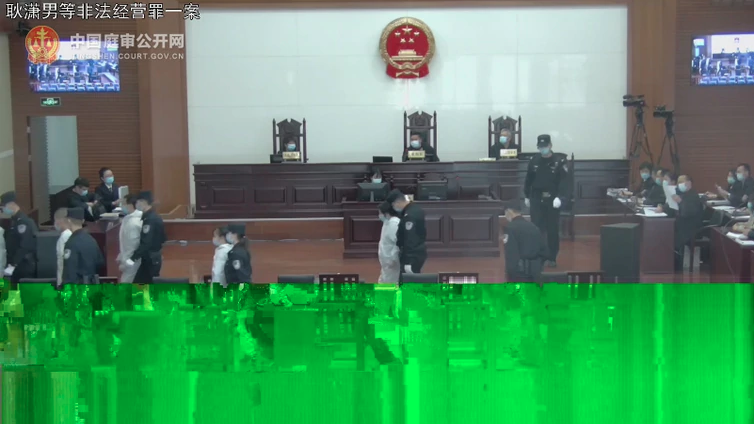 耿瀟男案今（9日）早上10時20分在北京開審，法院進行直播，期間頻頻卡畫面，難以清晰見到耿瀟男的樣子。畫面中央的女犯人疑爲耿瀟男。（圖片來源：視頻截圖）