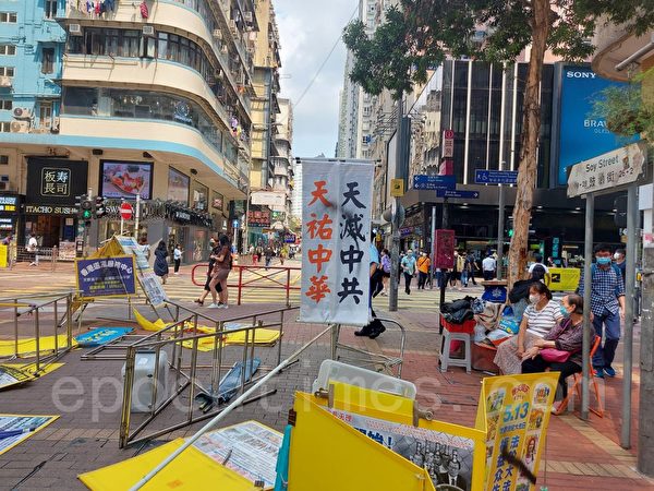 4月2日，4名歹徒在香港旺角豉油街法轮功真相点实施暴行，他们扯烂罗马旗，用尖刀划破展板，并将黑墨喷在横幅上。（法轮功学员周小姐提供）