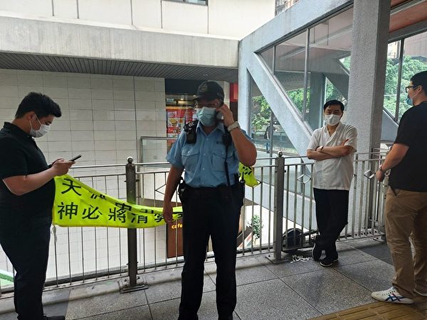 白衣男子4月7日在香港湾仔天桥扯下法轮功学员的标语，被员警拘捕。（法轮功学员周小姐提供）