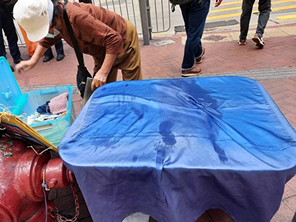 4月8日，香港铜锣湾法轮功真相点的报纸遭恶徒泼湿。（法轮功学员周小姐提供）