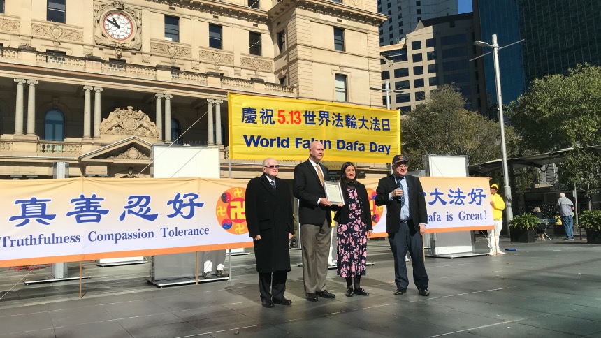 威爾森先生和尼爾先生爲澳洲法輪大法佛學會主席Lucy Zhao 和副主席John Deller頒發褒獎書。