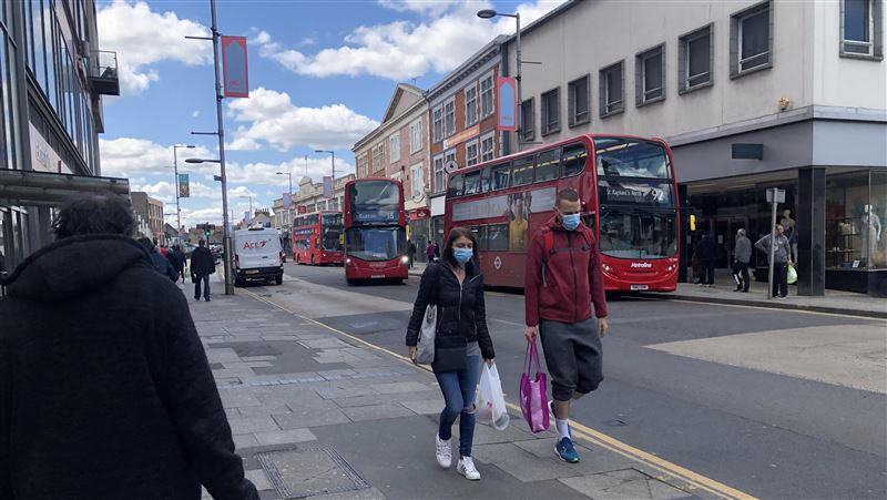 英國宣布延後解封1個月。圖為倫敦街頭民眾戴口罩。
