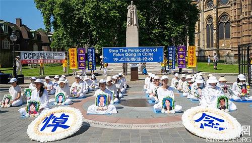 2021年7月18日，英國法輪功學員在倫敦議會大廈對面的議會廣場上舉行“7.20”反迫害集會。（圖片來源：明慧網）