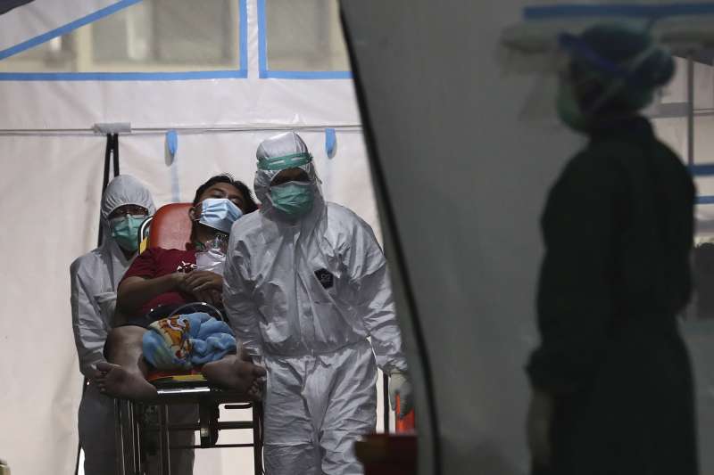 6月24日，印尼雅加達的珍加連地區綜合醫院，醫護人員用擔架將一名新冠病患抬離緊急搭建的帳篷
