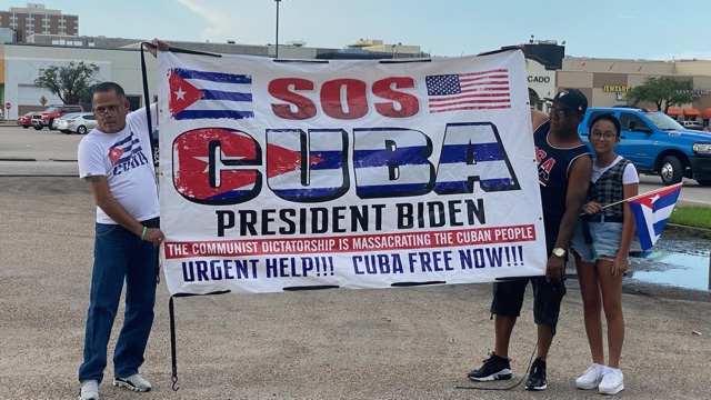 7月18日（周日）晚6点，在休斯顿西南区Sharpstown购物中心前，古巴裔美国人集会抗议古巴共产政权对示威群众的残酷镇压，集会参与者展示横幅。（SOH/姜书瑶）