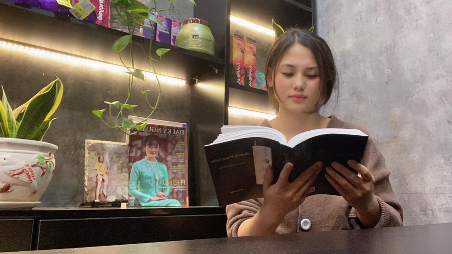 越南河内的美发店老板陈宝贷（Bao Loan）女士在看越南文版《转法轮》（DKN.tv）