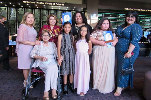 2022年4月30日下午，地產公司老闆Rachel Uliberri（後排身穿紅衣者）和妹妹Juanita Vazquez（左一）、母親Michaela Villarruel（前排左一）攜一家四代八口人，共同觀看了神韻紐約藝術團在棕櫚沙漠麥卡倫劇院的第三場演出。（姜麗／大紀元）