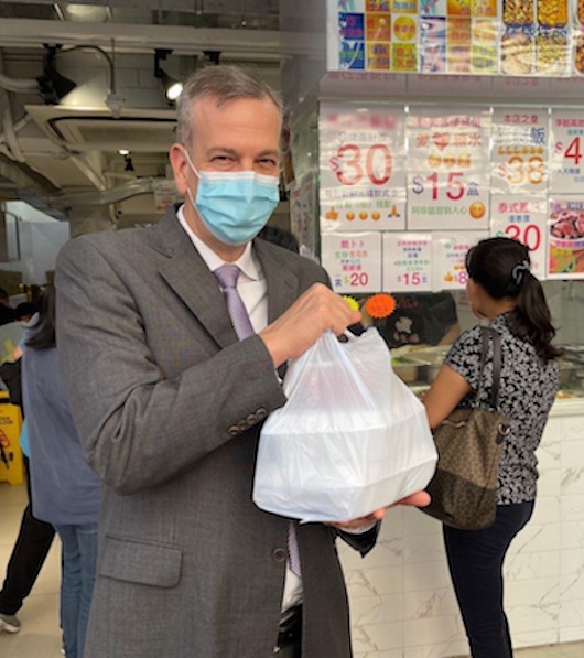 美國駐港澳領事館總領事Greg May （梅儒瑞）嘗香港打工族「兩餸飯」滋味。（圖片來源：國駐港澳領事館臉書）