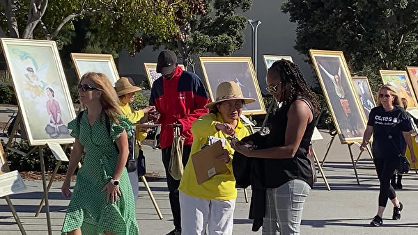 2022年10月29日，加州聖地亞哥法輪功學員在聖地亞哥港口公園舉行《真善忍畫展》，過往行人駐足觀看並簽名支持法輪功發迫害和“解體中共”（圖片來源：大紀元）