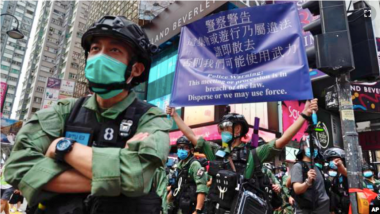 香港警方在慶祝中國共產黨建立中華人民共和國的節日期間在銅鑼灣街向抗議者舉出警告旗幟